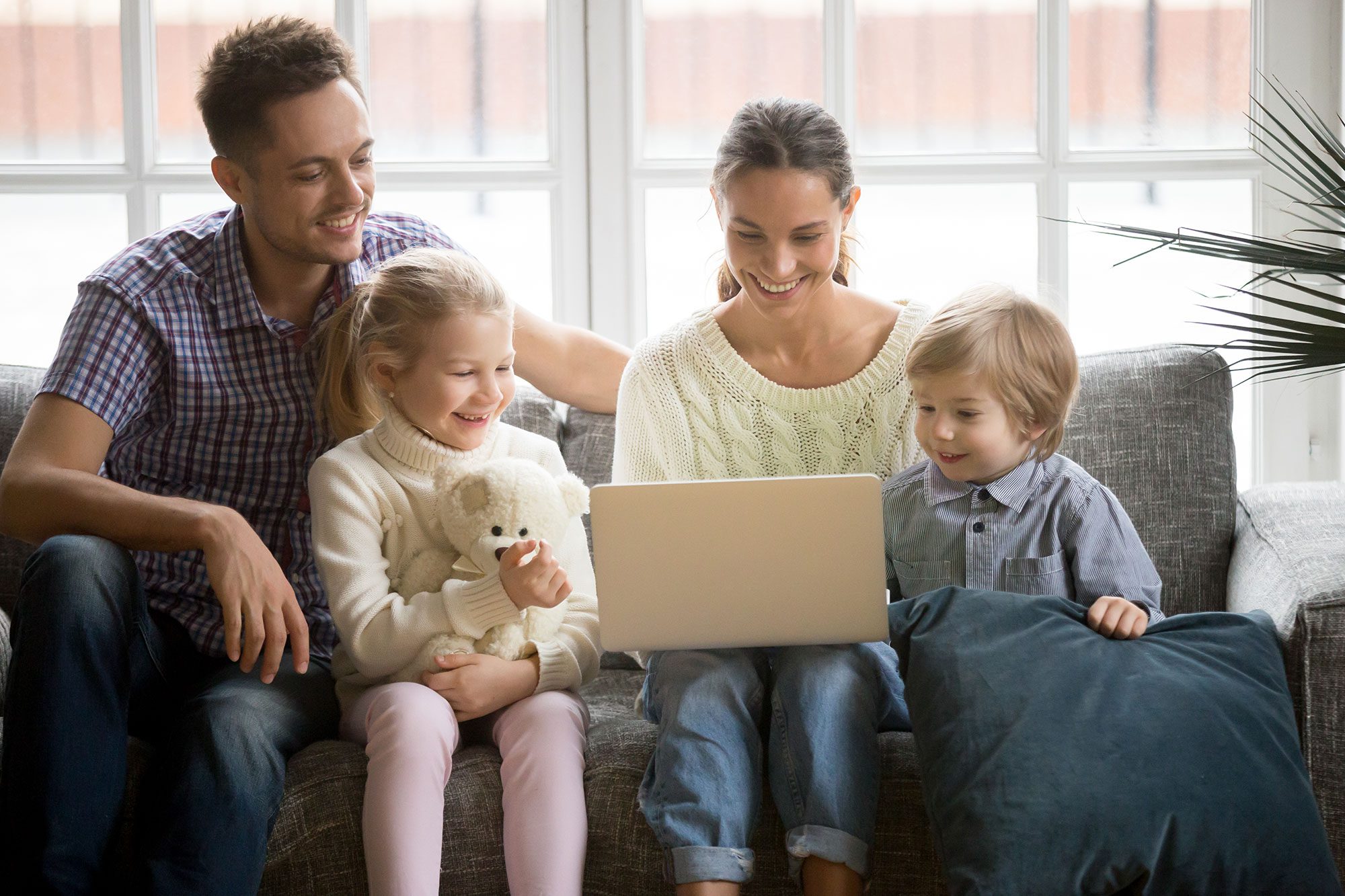 happy-family-with-children-having-fun-using-laptop-sofa